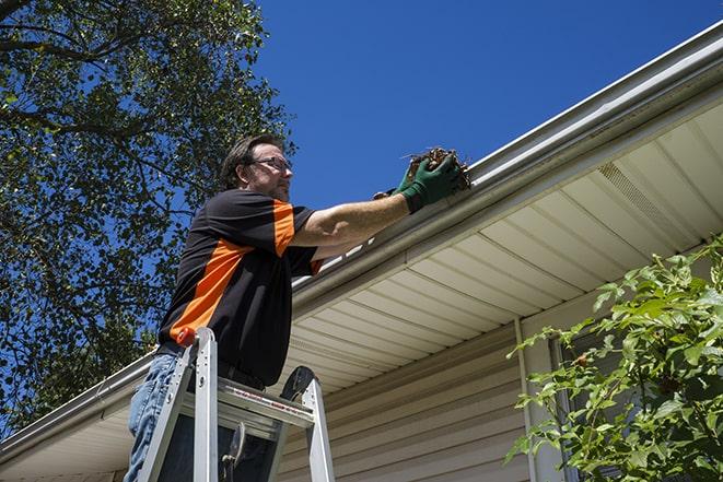 two workers fixing a gutter on a residential house in Brookfield WI